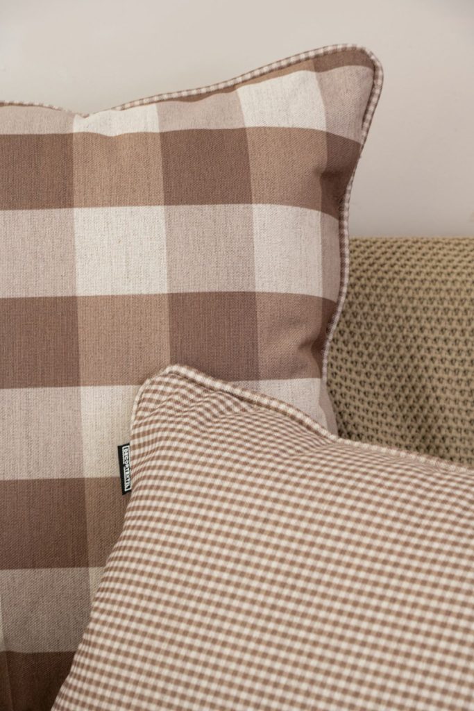 Composição de almofadas estampadas com acabamento em cordão xadrez