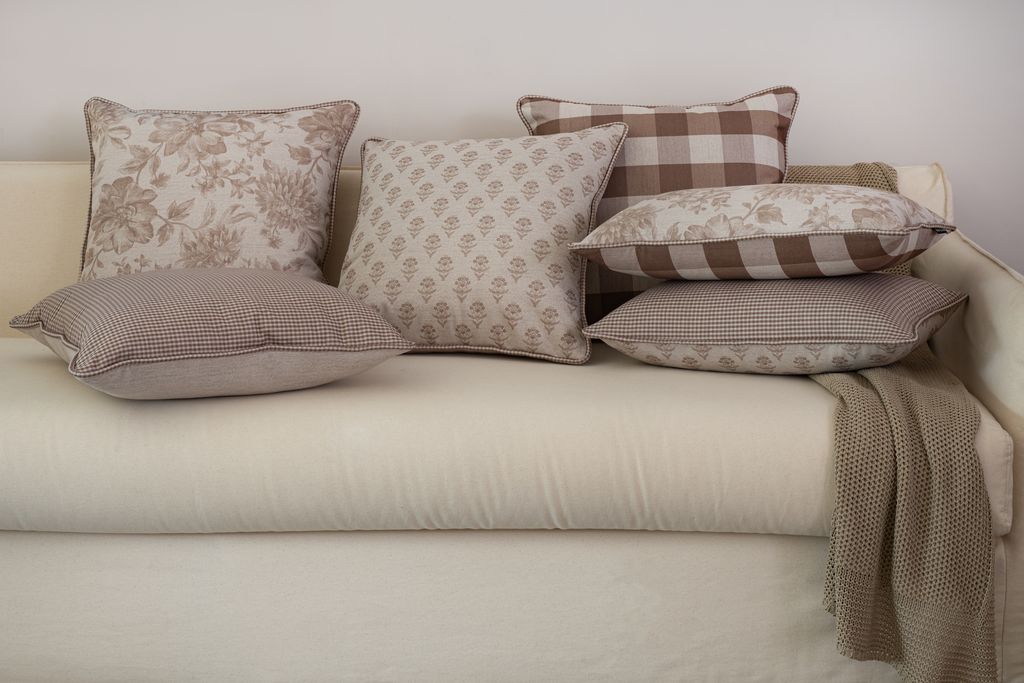 Almofadas decorativas com estampas xadrez, floral e buti em tons neutros
