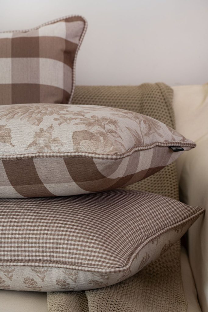 Detalhe de almofada com cordão xadrez e tecido de linho estampado