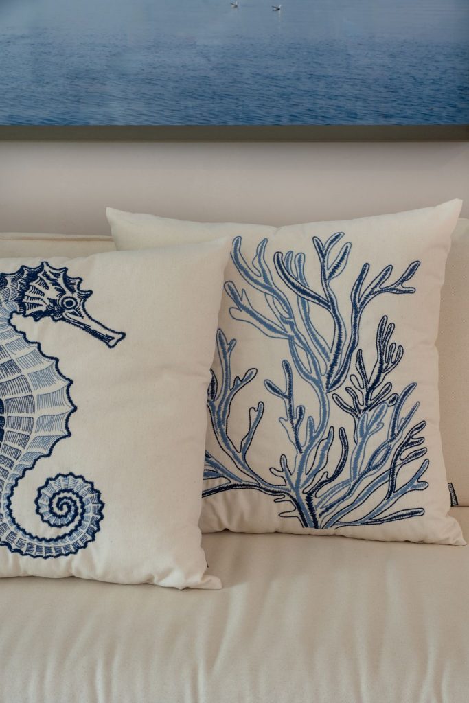 Composição de almofadas bordadas em ambiente de área gourmet, evidenciando profundidade dos bordados e elegância na decoração.