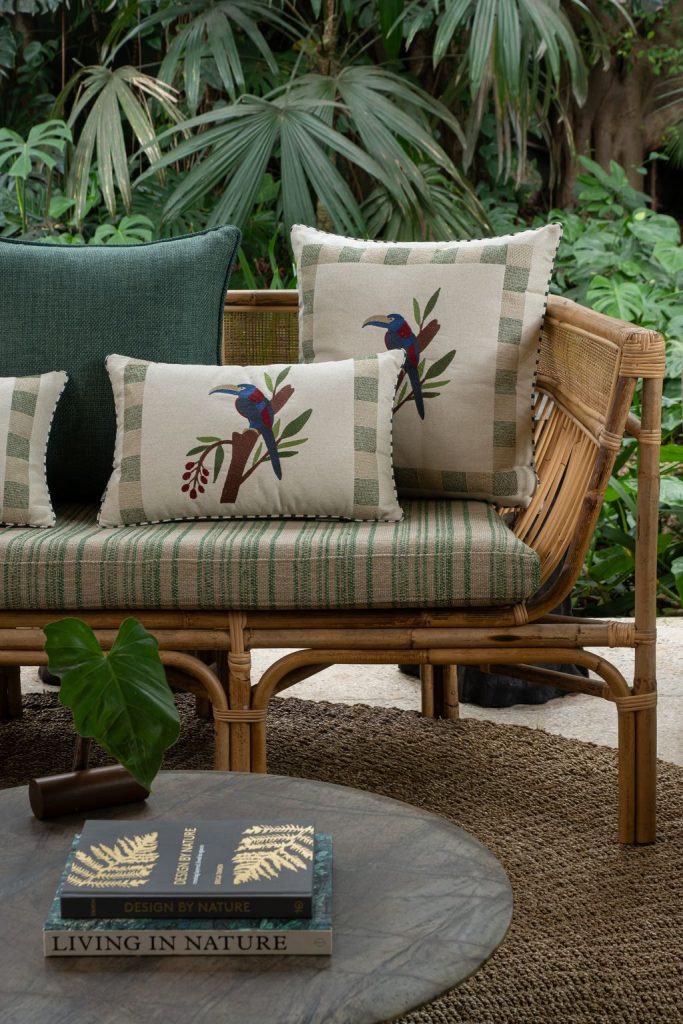 Almofadas decorativas da Decortextil com bordados delicados e inspiração tropical em sofá de ambiente elegante.