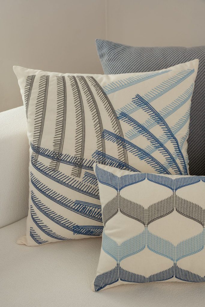 Almofadas decorativas com bordados ricos em detalhes e desenhos geométricos em uma composição elegante e contemporânea.